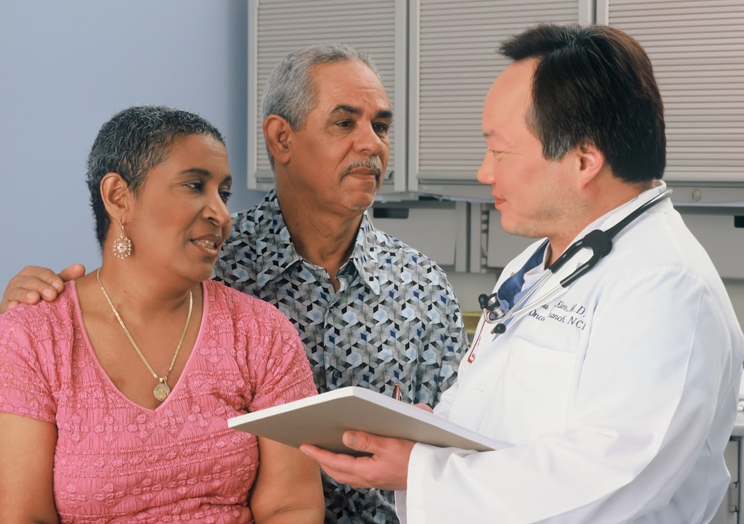 Doctor consults with a couple in a clinic room.