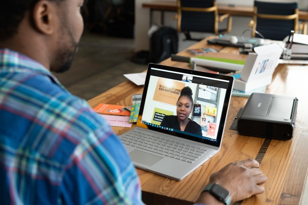 Man on laptop video call supporting Black-owned businesses.